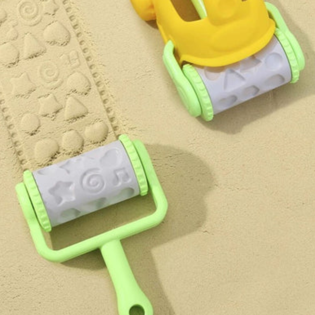 Close-up of Tookyland pattern rollers creating star and spiral imprints in soft play sand.
