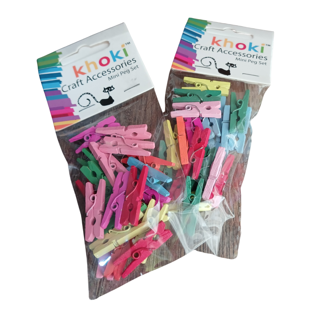Khoki Craft Accessories Mini Peg Sets filled with small, colorful wooden craft pegs in shades of pink, green, yellow, blue, and red against a dark background.