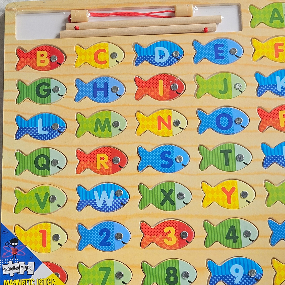 Close-up of the magnetic letter and number fishing board, showing the alphabet fish pieces and fishing rod with magnet line
