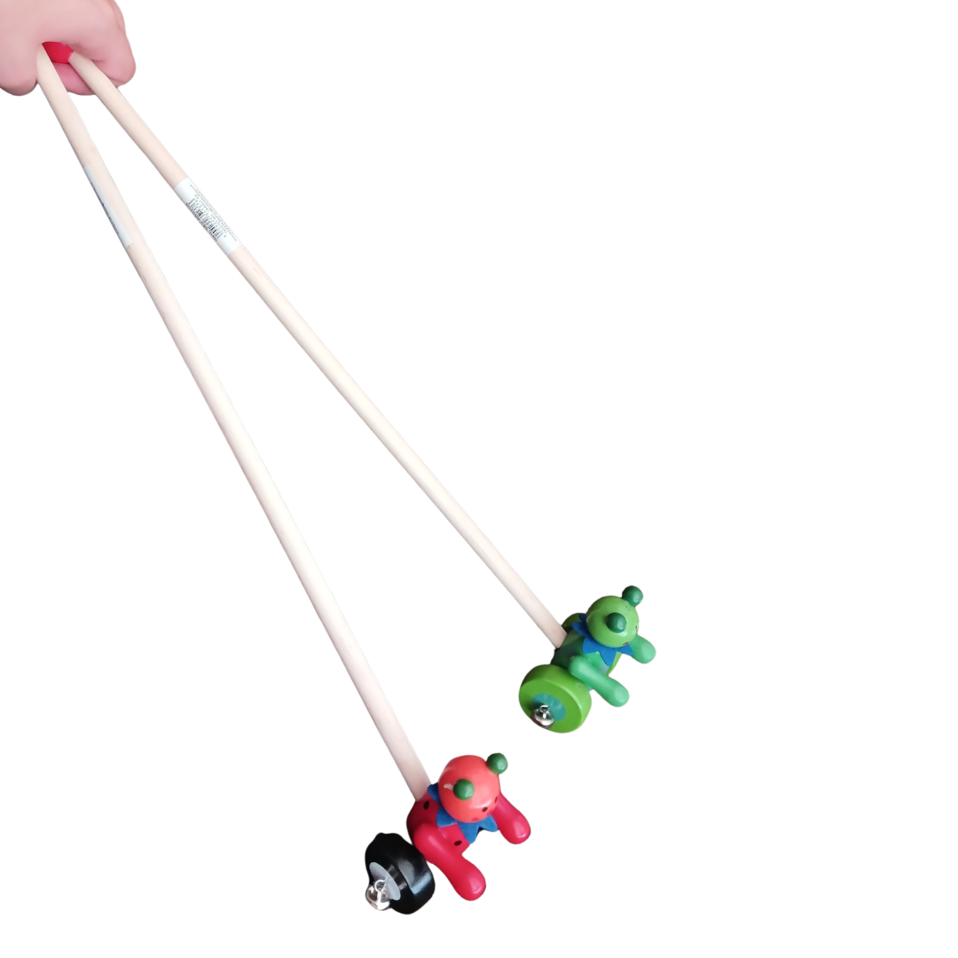 Red and green wooden push toys with long handles held by hand