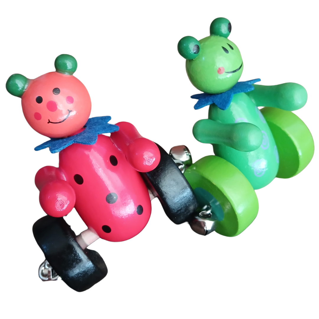 Close up view of red ladybug and green frog wooden push toys with jingling bells